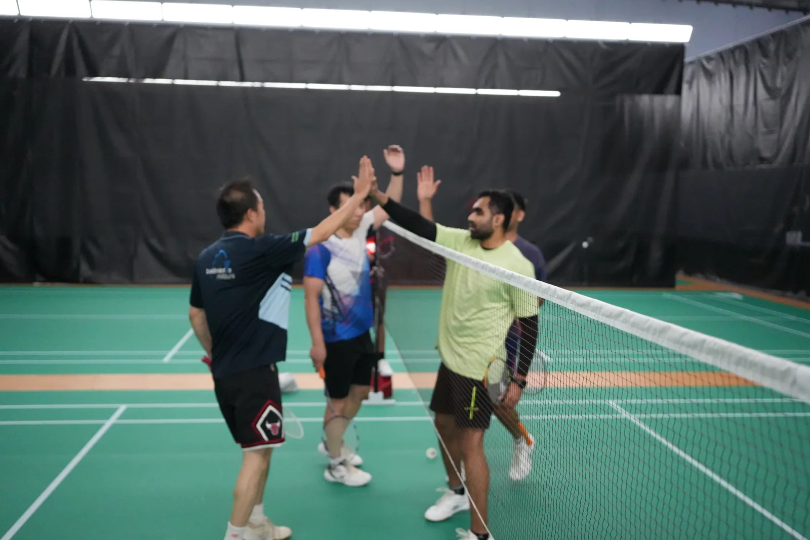 Players sharing high-fives across the net at the WBi tournament