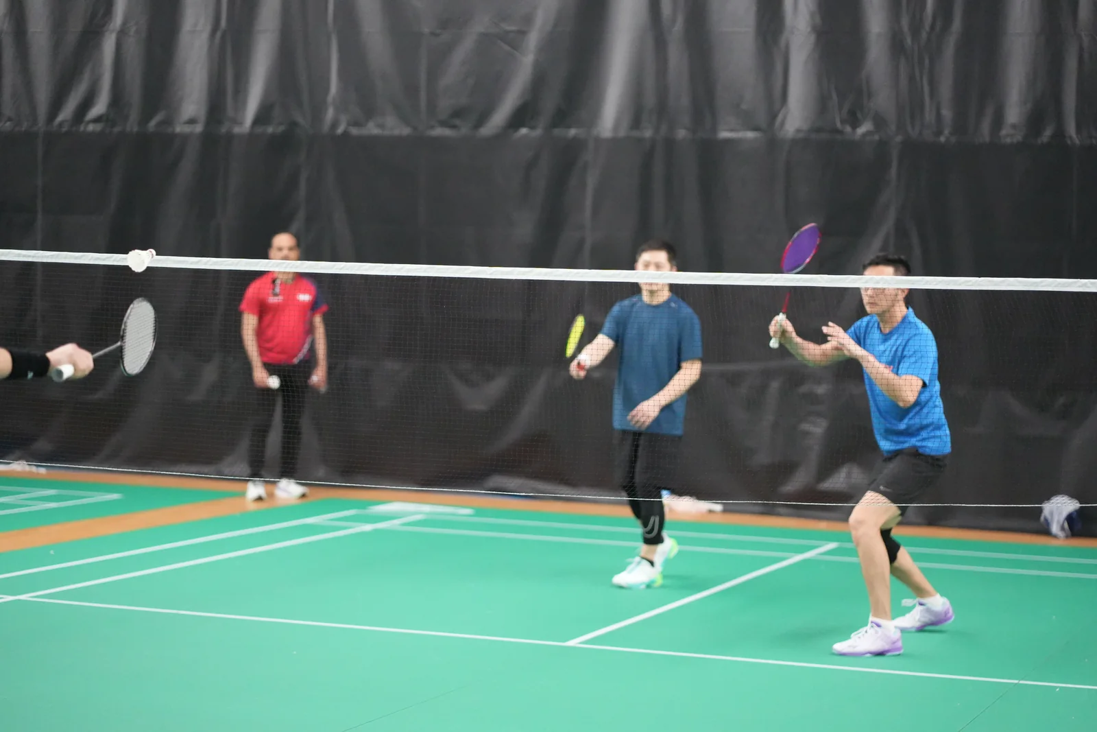 Two players in blue preparing for a doubles rally at the WBi Flagship Doubles Tournament 2026